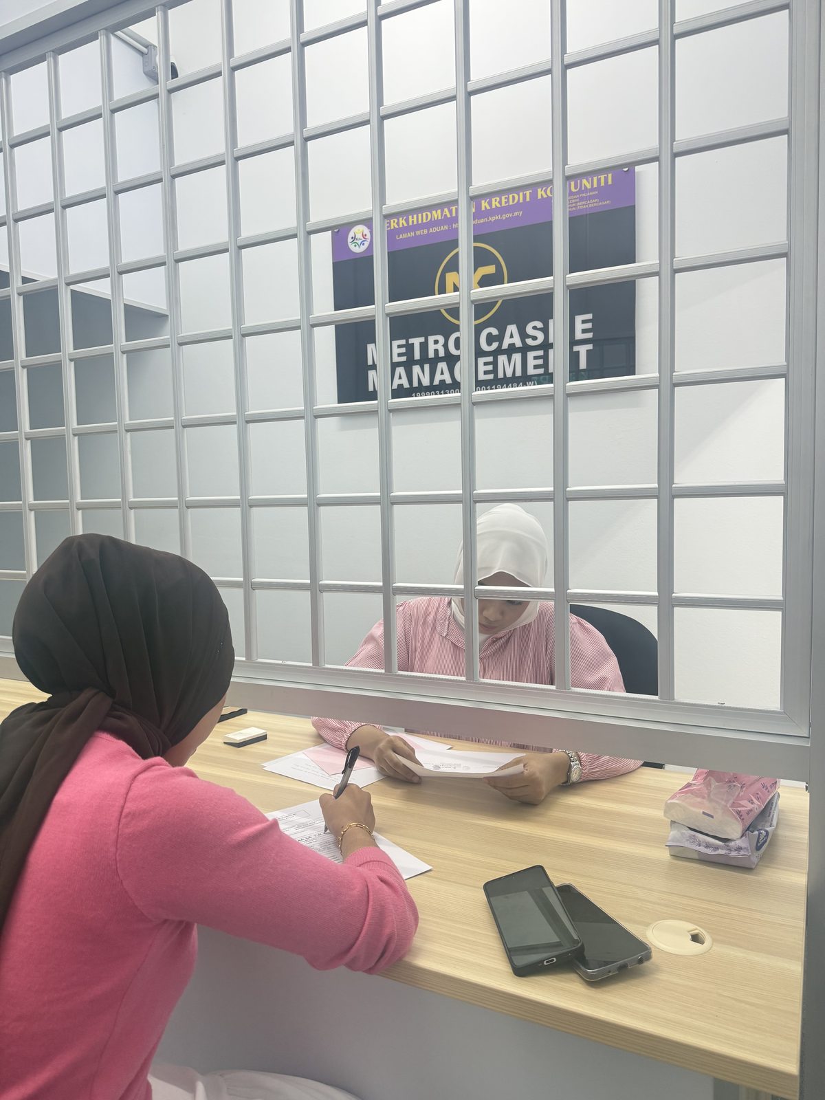 Pegawai Metro Cashe Management berbincang dengan pelanggan di kaunter pejabat