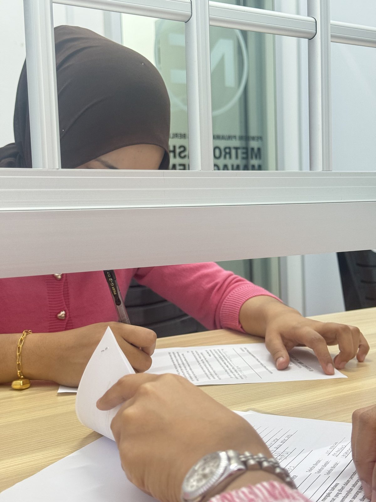 Pelanggan menandatangani perjanjian pinjaman di kaunter pejabat Metro Cashe Management